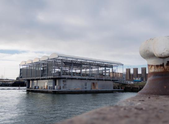 Op de plek waar vroeger de gevangenisboot lag, ligt nu de eerste drijvende boerderij ter wereld