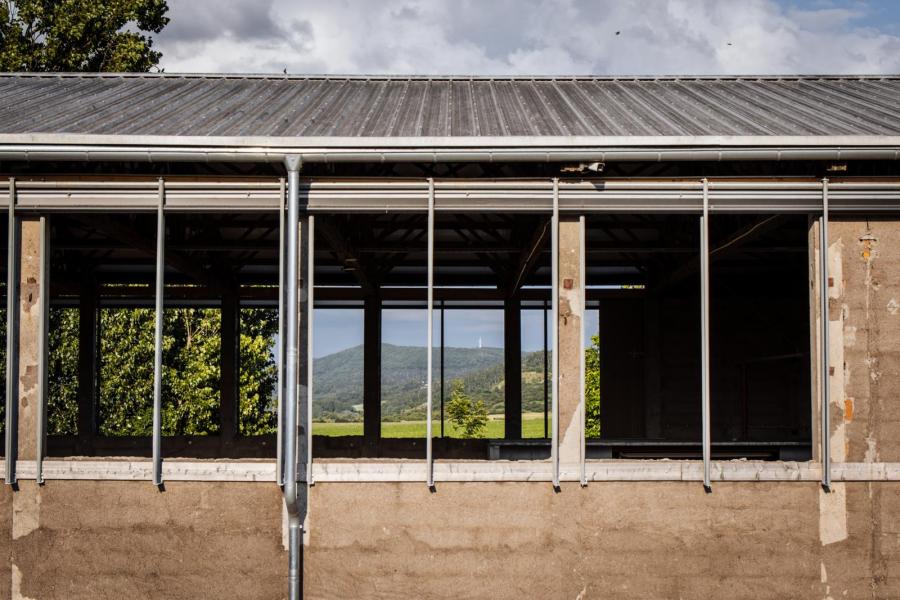 De bovenste helft van de betonnen wanden van de loods is gesloopt om ventilatie te realiseren